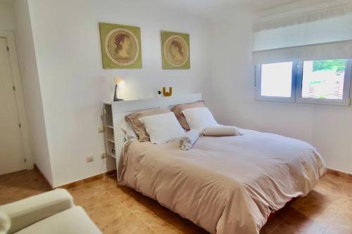 biała sypialnia z dużym łóżkiem z białą pościelą w obiekcie Apartamento Porto do Xufre w mieście Isla de Arosa