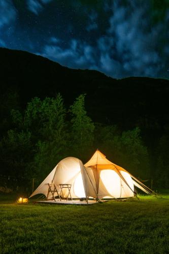 a couple of tents in a field at night at Glamping Gozdna Jasa in Bovec