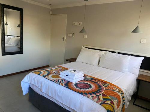 a hotel room with a bed and a mirror at @20401 in Gaborone