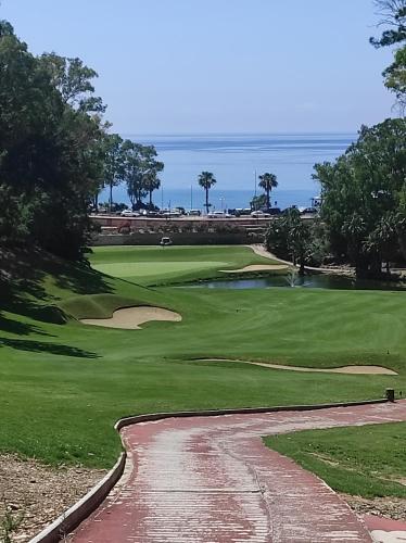 a view of a golf course with the ocean in the background at Dream Sea Golf & Beach in Benalmádena