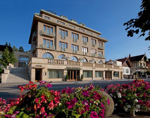 a large building with flowers in front of it at Alexandria Spa & Wellness Hotel in Luhačovice