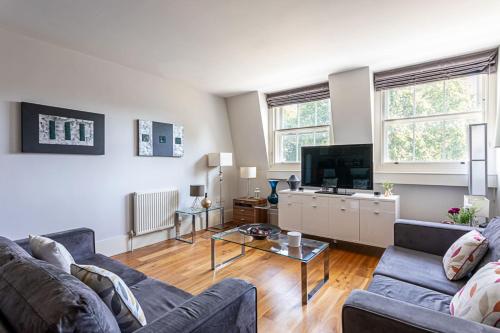 a living room with two couches and a tv at Holborn Flat with Green Views in London