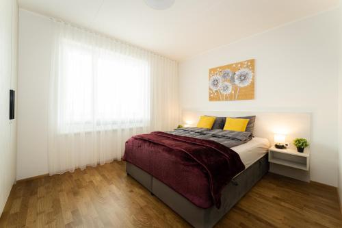 a bedroom with a bed and a large window at Citygate Sunset balcony in Tartu