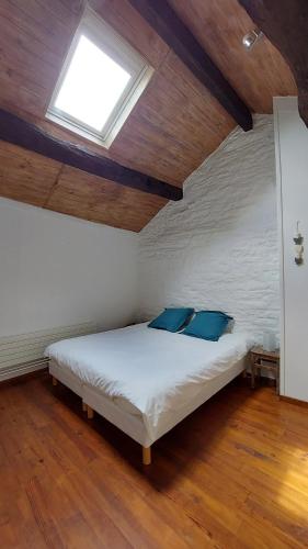 een slaapkamer met een wit bed met blauwe kussens bij Gîtes la Molière Haute in Plaisance