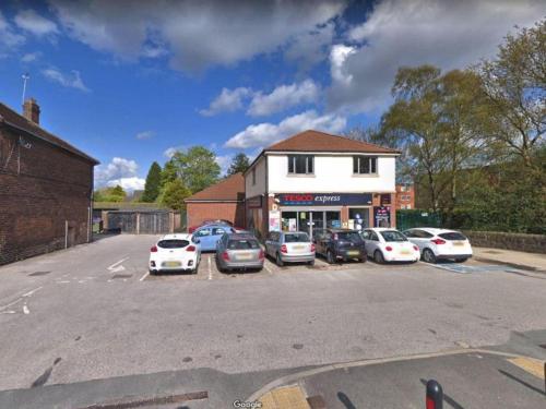 a parking lot with cars parked in front of a building at Home in Alwoodley, Leeds