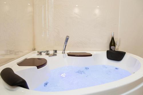 a bath tub with a sink and a bottle of wine at The Bricks B&B Free Parking in Pisa