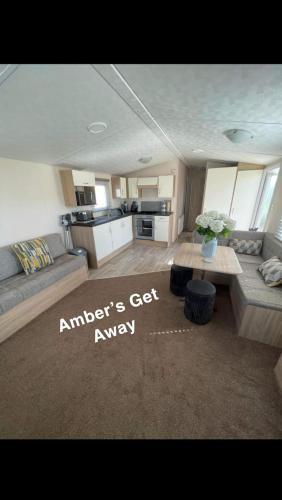 ein Wohnzimmer mit einem Sofa und einem Tisch in der Unterkunft Amber’s Get Away in Skegness