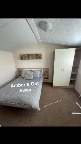 a bedroom with a bed and white cabinets at Amber’s Get Away in Skegness