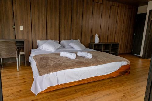 a bedroom with a large bed with two towels on it at Guayupes Hotel de Aventura in Guamal