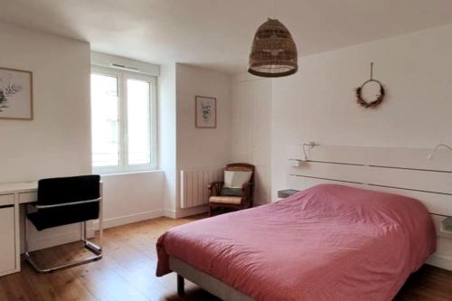 Schlafzimmer mit einem Bett, einem Schreibtisch und einem Fenster in der Unterkunft Belle époque in Granville