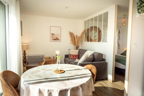 a living room with a table and a couch at Leptitchezsoi, calme et cosy à 5 mn du centre de Bayeux in Vaucelles