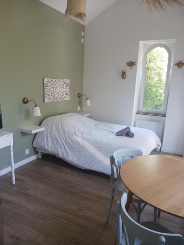 1 dormitorio con 1 cama, mesa y sillas en La laiterie de la Plume en Nantes