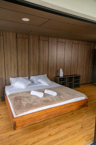 a bedroom with a large bed with two towels on it at Guayupes Hotel de Aventura in Guamal
