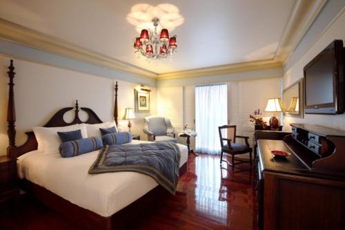 a bedroom with a large bed and a chandelier at Tuli Imperial in Nagpur
