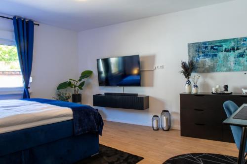 ein Schlafzimmer mit einem Bett und einem TV an der Wand in der Unterkunft Uniklinik-Nähe Modernes Apartment, mit Balkon in Wuppertal