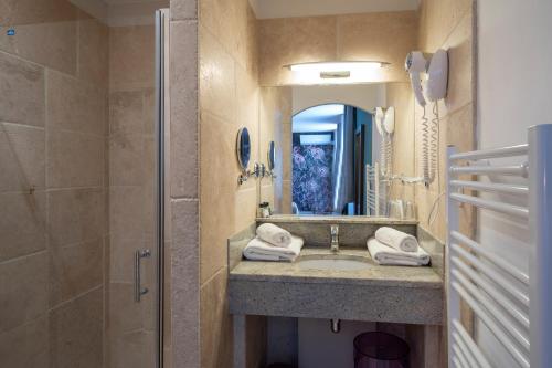 y baño con lavabo, ducha y espejo. en Hôtel LA MARGELLE en Pernes-les-Fontaines
