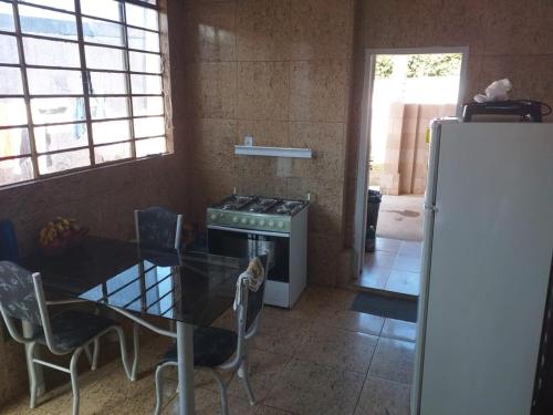 a kitchen with a table and a stove and a refrigerator at Hostel Bimba Goiânia - Unidade 01 in Goiânia