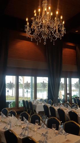 a dining room with tables and chairs and a chandelier at Hotelli Viikinhovi in Keuruu
