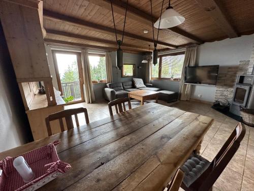 una gran mesa de madera y sillas en la sala de estar. en Haus Weitblick, en Sirnitz-Sonnseite