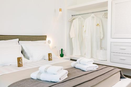 a white bedroom with towels on a bed at Orelia Luxury Villas in Amoopi