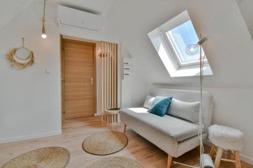 sala de estar con sofá y ventana en Résidence Jean Hardy - Hyper centre, parking gratuit, wifi, clim, gare, en Valenciennes
