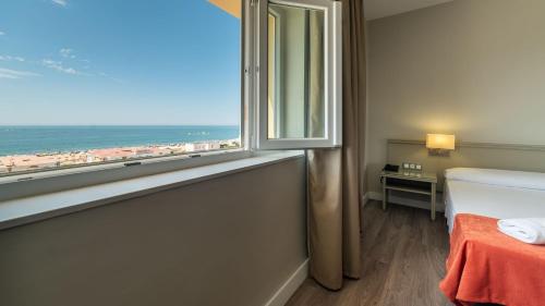 a bedroom with a window with a view of the beach at Pato Rojo in Punta Umbría