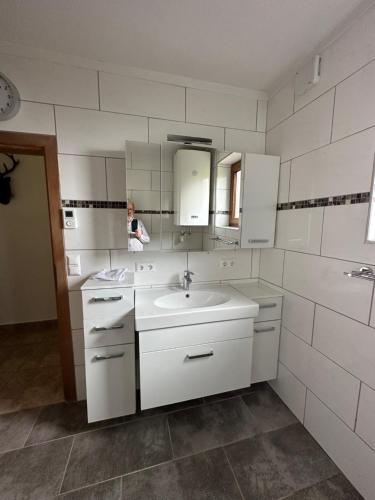 Eine Frau in einem weißen Badezimmer mit Waschbecken in der Unterkunft Haus Weitblick in Sirnitz-Sonnseite
