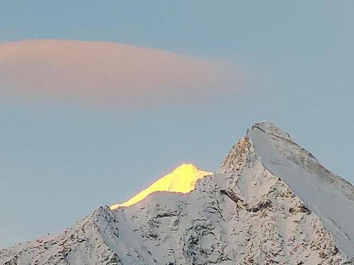 a snow covered mountain with the sun shining on it at B&B Alpenrösli in Gasenried