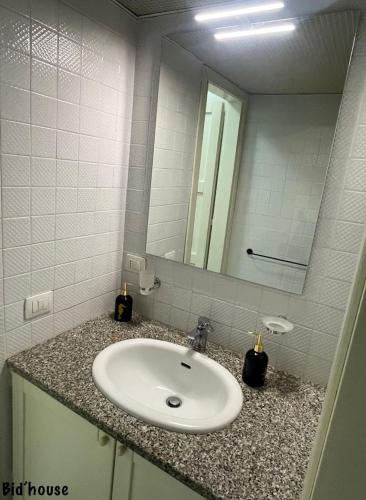 a bathroom with a sink and a mirror at isola rossa fronte mare apartment in Isola Rossa