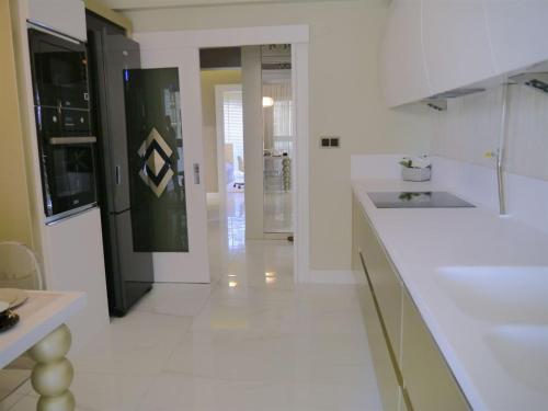 a white kitchen with a sink and a counter at SELAM REZİDANCE BUİLDİNG LUXURY APARTMENT in Hamitler