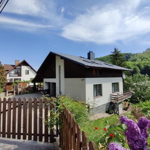 a house with a fence and flowers at Ubytování - Černá hora II in Svoboda nad Úpou