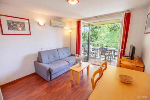 a living room with a couch and a table at Olydea la Chalosse - Cassen in Cassen