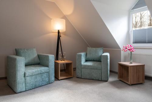 two chairs and a lamp in a room at Hotel Grosse Klus in Bückeburg