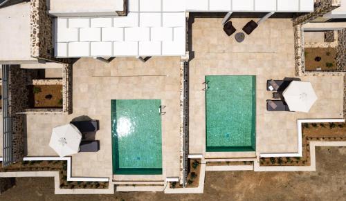 - une vue sur la piscine avec deux espaces verts dans l'établissement Orelia Luxury Villas, à Amoopi