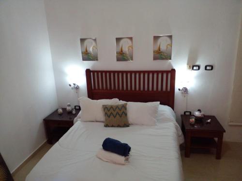 Las Lagunas的住宿－Private Apartment in Caribe Dominicus 3 SOLO ADULTOS，卧室配有一张带两张桌子的大型白色床