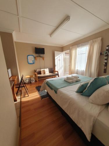 ein Schlafzimmer mit einem großen Bett und einem Sofa in der Unterkunft Affieplaas Selfsorg in Kimberley