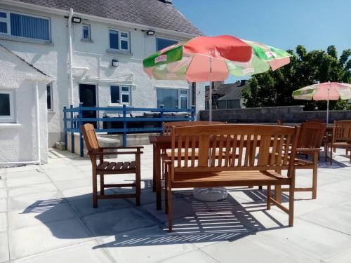 a table and chairs and an umbrella on a patio at Anglesey home by the sea in Amlwch