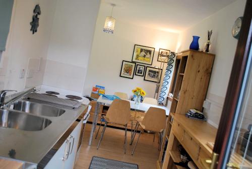 a kitchen with a sink and a table with chairs at 4 Laigh Isle in Isle of Whithorn