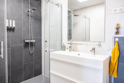een badkamer met een witte wastafel en een douche bij Het Gelders Buitenleven in Overasselt