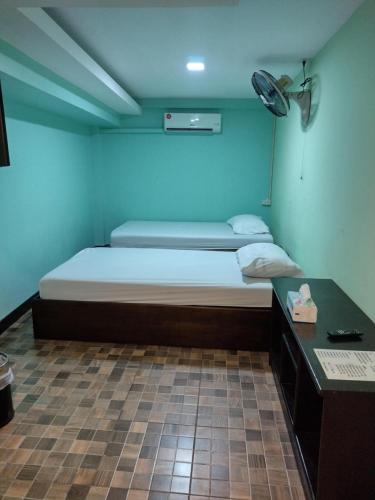 um pequeno quarto com uma cama e uma secretária em Friendly Hostel - DMK Airport เฟรนด์ลี่ โฮสเทล ดอนเมือง em Ban Don Muang (1)
