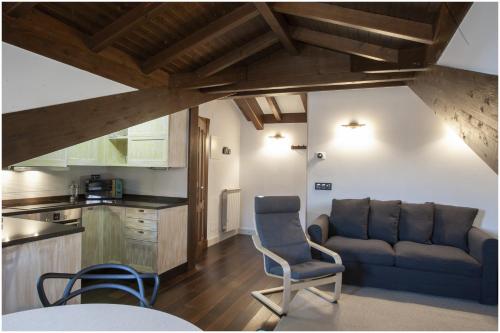 a living room with a couch and a kitchen at Aticos La Riba in Luanco