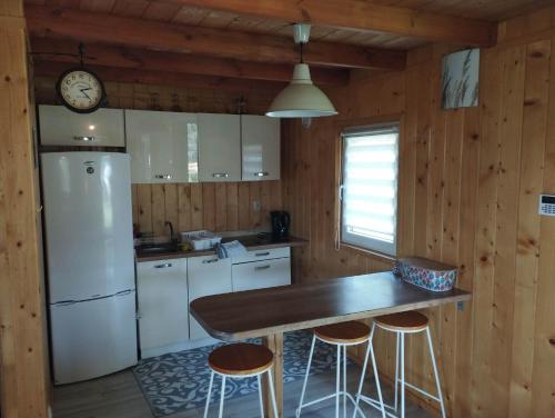 eine Küche mit einem Kühlschrank, einem Tisch und Stühlen in der Unterkunft Osada nad żurawim stawem in Krzywogonice