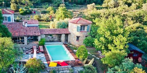 - une vue aérienne sur une maison avec une piscine dans l'établissement L’Hacienda Maison d’hôtes, à Bagnols-en-Forêt
