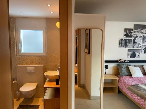 una camera da letto con un letto e un bagno con un lavandino di Cornelia a Saas-Fee
