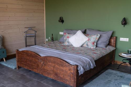 a bedroom with a large wooden bed with pillows at Istvándy Birtok in Káptalantóti