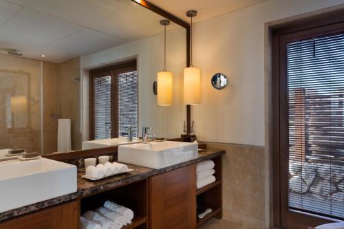 a bathroom with two sinks and a large mirror at Beresheet by Isrotel Exclusive in Mitzpe Ramon
