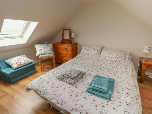 a bedroom with a bed and a dresser and a window at Ystabl Robyn in Carmarthen