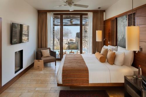 a bedroom with a large bed and a fireplace at Beresheet by Isrotel Exclusive in Mitzpe Ramon
