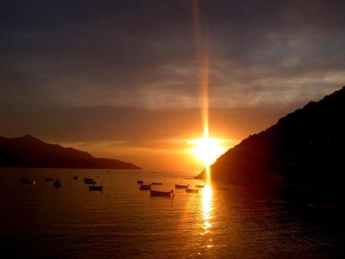 a sunset over a lake with boats in the water at Villa mit Whirlpool und phantastischer Aussicht in Capoliveri