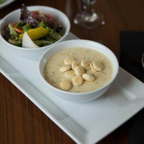 a bowl of soup and a salad on a white plate at Hyatt Regency Boston in Boston